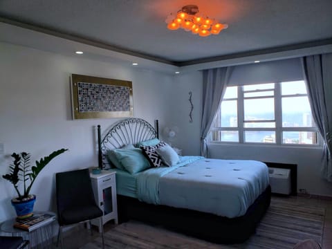 Queen bed with sweeping ocean and city views. 