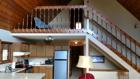 Kitchen with view of loft and upper bedroom with full bath