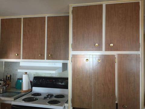 Kitchen is well equipped with major appliances, sink, pans, dishes, and more.