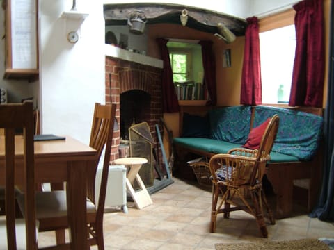 One side of  sitting room with wood and coal burning open fireplace. 