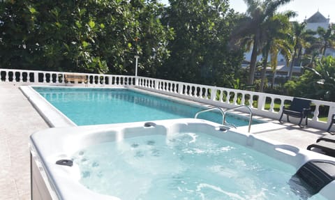 Swimming pool with Jacuzzi also BBQ pit on the ground to the left of the pool 