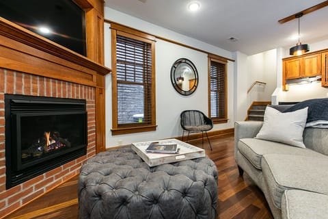 Main downstairs living space with fireplace and tv.
