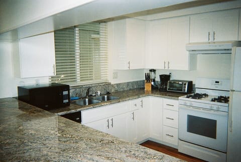 All new kitchen with granite counter, white shaker cabinets, sink, and fixtures