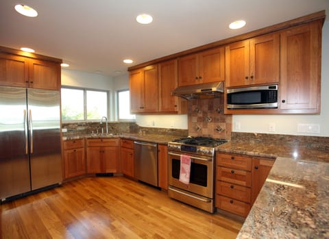 Granite countertops, cherry cabinets and dual fuel range adorn gourmet kitchen.