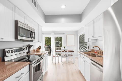 The eat-in kitchen has stone counters and hardwood floors.