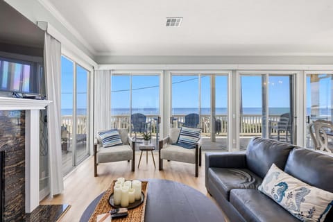Relax in a bright, comfortable living room with breathtaking ocean views and direct access to the beachfront deck