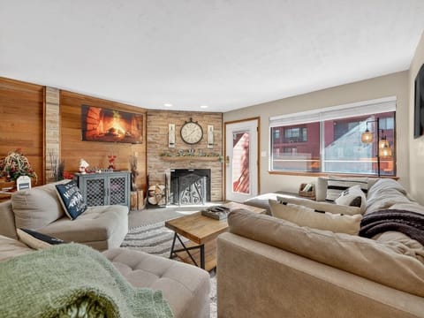 Unwind in your cozy living space featuring a stone fireplace and plush seating that invites you to relax after mountain adventures.