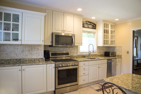 Newer Stainless Steel Kitchen Aid appliances, gas range, and custom backsplash