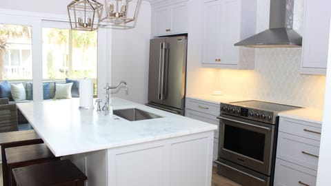 Special details in the kitchen includes a soft blue ceiling and steel range hood.
