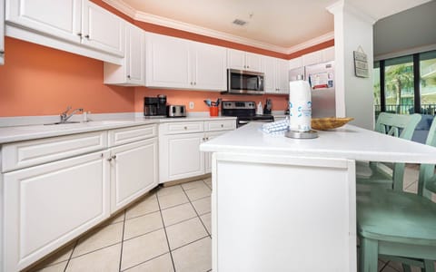 Prepare meals in this kitchen with a coffee corner, Keurig and traditional, stainless appliances and open design