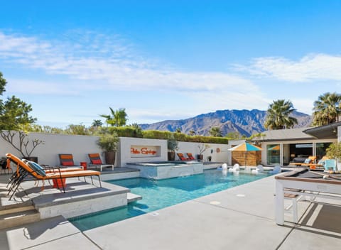 Backyard large pool and jacuzzi, grill, bar area, and fire pit in Palm Springs