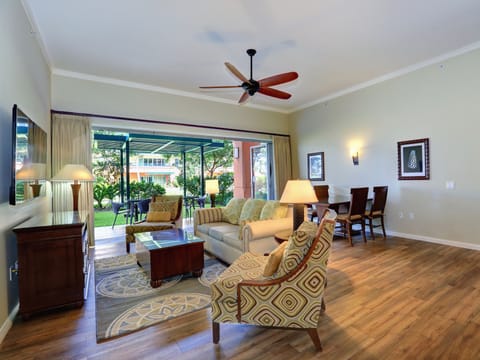 living area, wall mounted 65" 4k TV, wood tile flooring.