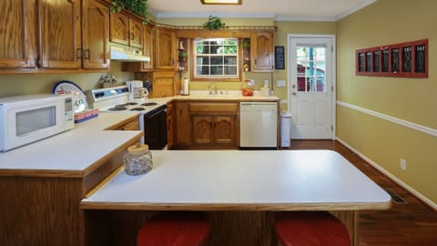 Fully furnished kitchen with oven, dishwasher, garbage disposal, and coffee pot.