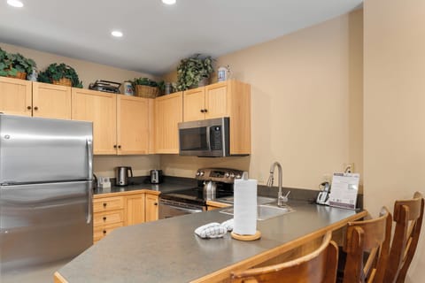Full kitchen with stainless steel appliances and breakfast bar with seating for 3