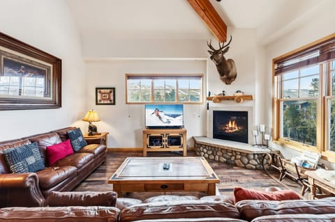 Cozy up in this inviting living room where warm leather seating surrounds a crackling fireplace, perfect for mountain evenings together.