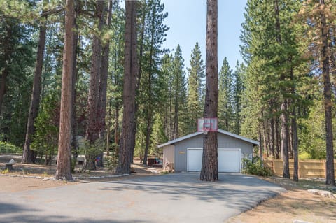 Front of the property featuring large driveway and basketball hoop