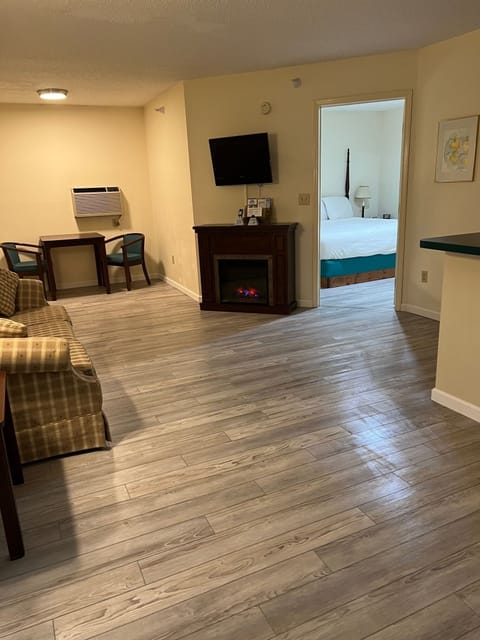 Deluxe Suite, 1 King Bed with Sofa bed, Jetted Tub, Fireplace | Living room | 32-inch flat-screen TV with cable channels, TV, video-game console