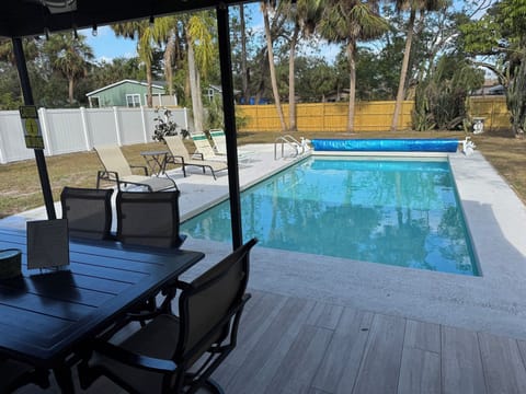 Fully fenced in yard with covered patio and refreshing pool.