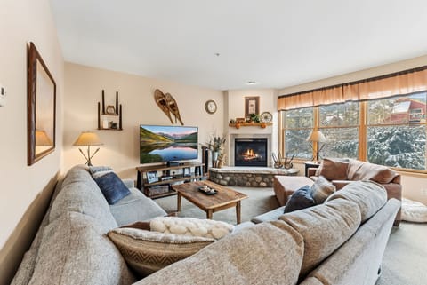 Living Room: L-shaped couch, plush armchair, TV, gas fireplace