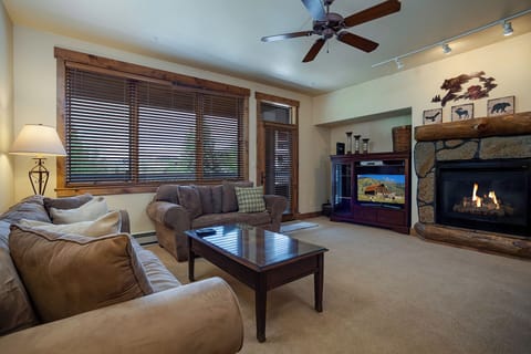 Sink into plush sofas by your crackling fireplace, where mountain decor and warm lighting create the perfect retreat for cozy evenings together.