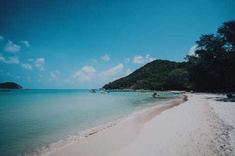 On the beach, white sand, beach umbrellas, beach towels