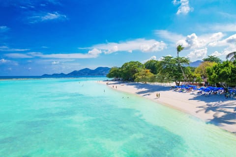 On the beach, white sand, sun loungers, beach umbrellas