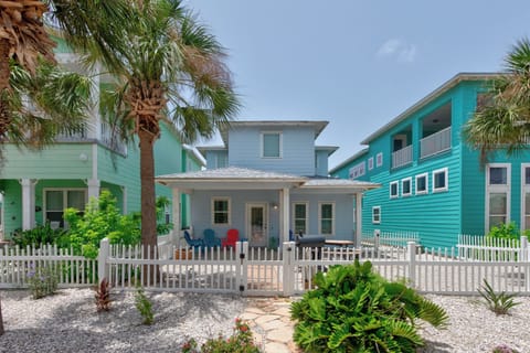 Bright beach house surrounded by colorful neighbors and swaying palms creates the perfect coastal getaway atmosphere.