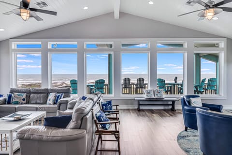 Your spacious living room frames endless ocean views through floor-to-ceiling windows. Sink into plush seating while watching waves roll in.