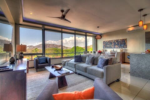 - Modern living room with panoramic mountain views   - Floor-to-ceiling windows flood space with natural light   - Relax in plush seating with flat-screen TV and sleek decor