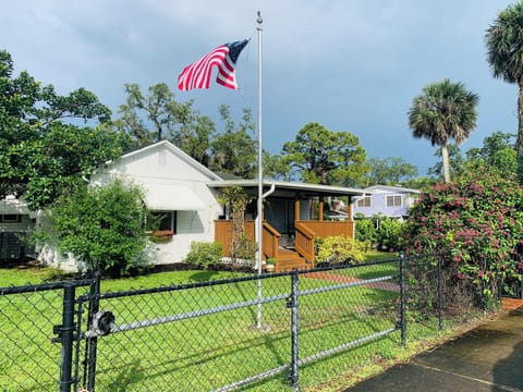 Front of the house - fully fenced, flagpole in the breeze.