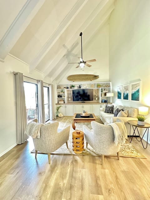 Living room features comfy seating and a 70 inch flat screen smart TV & cable. 