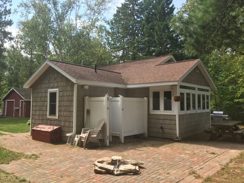 Patio with fire pit, outdoor shower, picnic table, and grill
