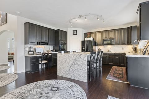 The kitchen also has a desk with a computer and printer.