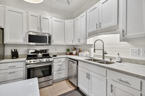 This modern kitchen features a gas stove, full cookware, sleek finishes, and a stocked coffee bar—perfect for slow mornings before exploring downtown Blue Ridge.  