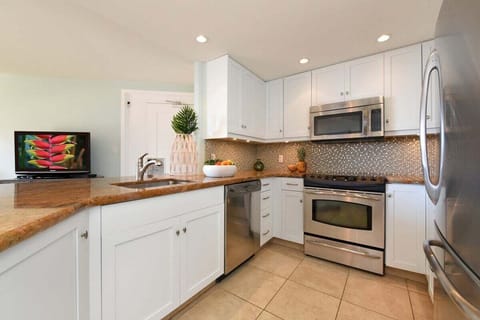 Modern kitchen with granite countertops and white wood cabinetry