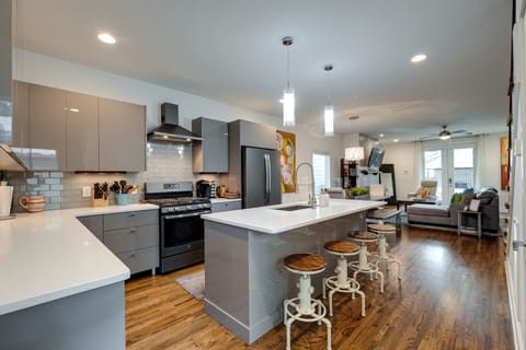 Kitchen with large island and industrial bar stools. Kitchen is stocked