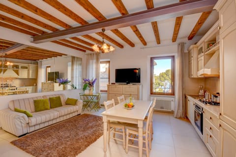 Open dining room with dining table, comfortable sofa bed and smart TV