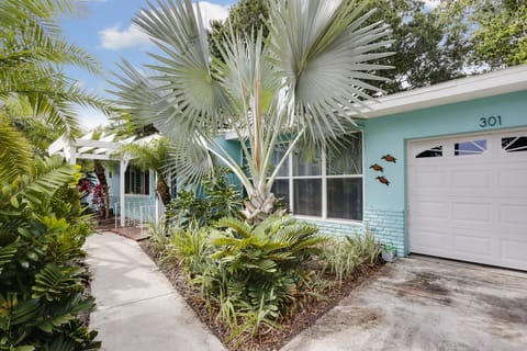 Front view, tropical paradise with lush landscaping, hassle free yard