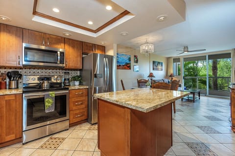 This fully equipped kitchen and open layout flow seamlessly into the dining and living spaces with stunning views of lush tropical greenery.
