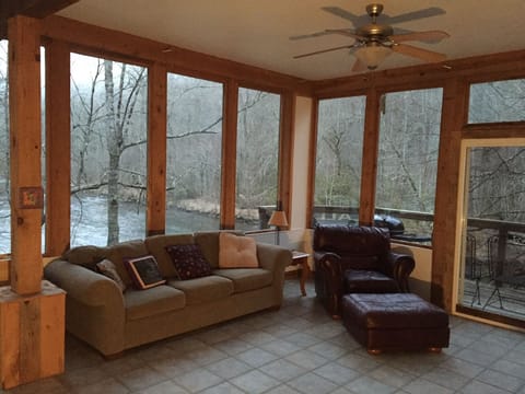 Great room surrounded by windows overlooking the river