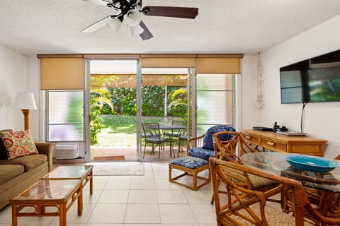 Living area looks out to lanai and lush landscaping