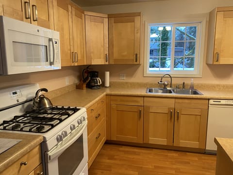 Fully equipped kitchen with gas range, dishwasher, microwave, and more.