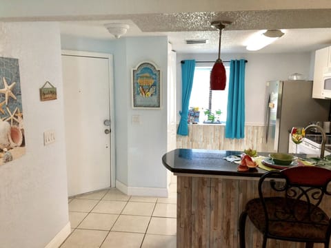 Looking at inside of Front Door Area , Bar Top Counter with Bar Stools.