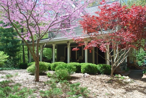 Beautiful wrap around porch nestled in the lush landscaping and woods!

