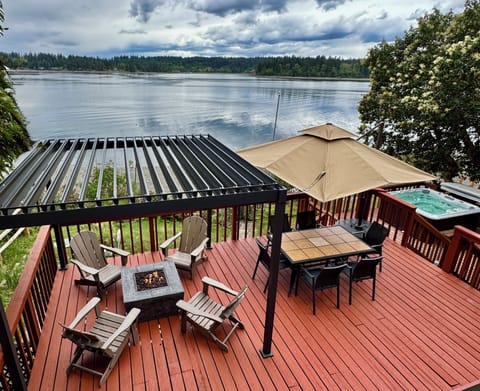 Spacious deck. Louvered pergola w/fire pit. Dining table w/umbrella. Hot tub.