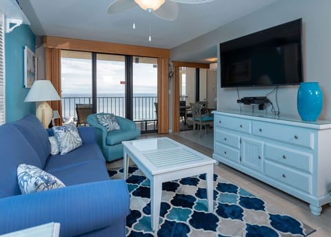 Inviting living area with beach views, featuring a cozy blue couch and a large flat-screen TV