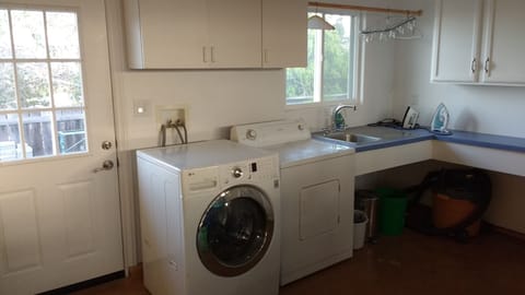 Laundry equipped with washer, dryer, iron & ironing board and outdoor line.