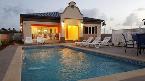 Pool, Pool Deck and front of villa at dusk