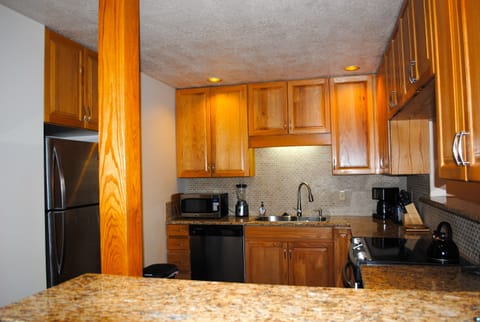 Fully stocked kitchen with new stainless steel appliances and granite counters
