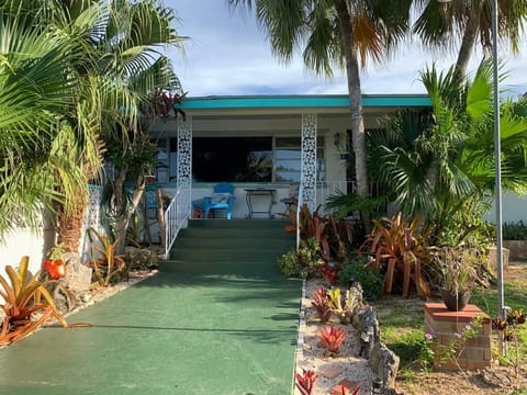 Front entrance to 3-bedroom home showing tropical foliage